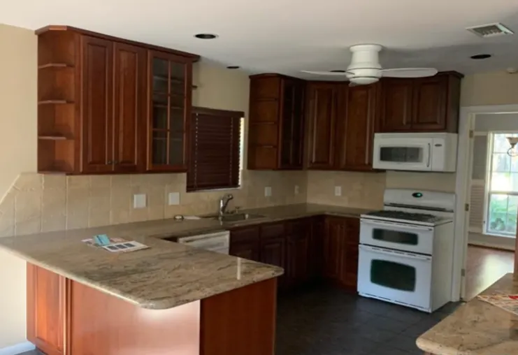 Original kitchen with dark cherry cabinets and granite peninsula