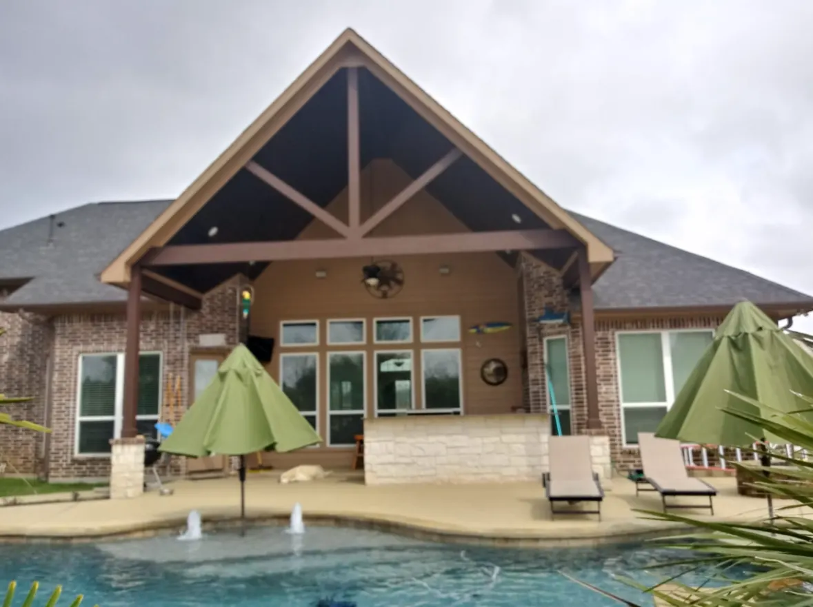 Finished gable patio cover with exposed truss over a backyard pool