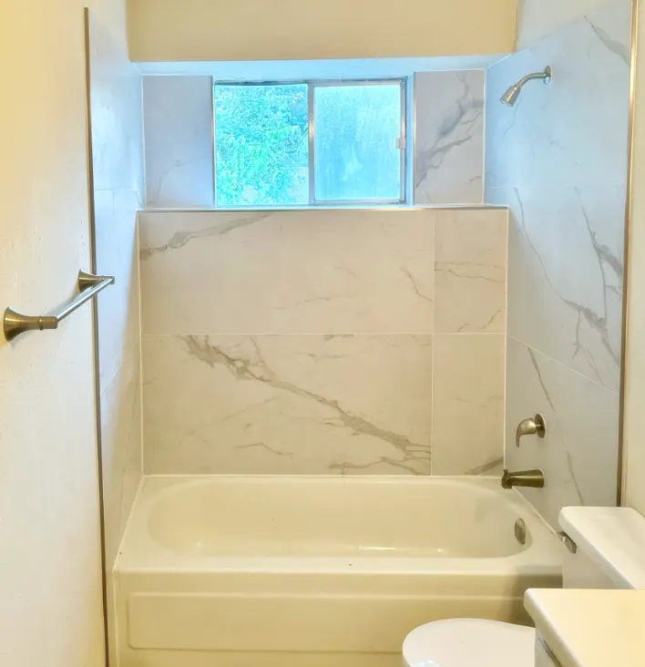 Finished tub surround in marble-look tile with new fixtures